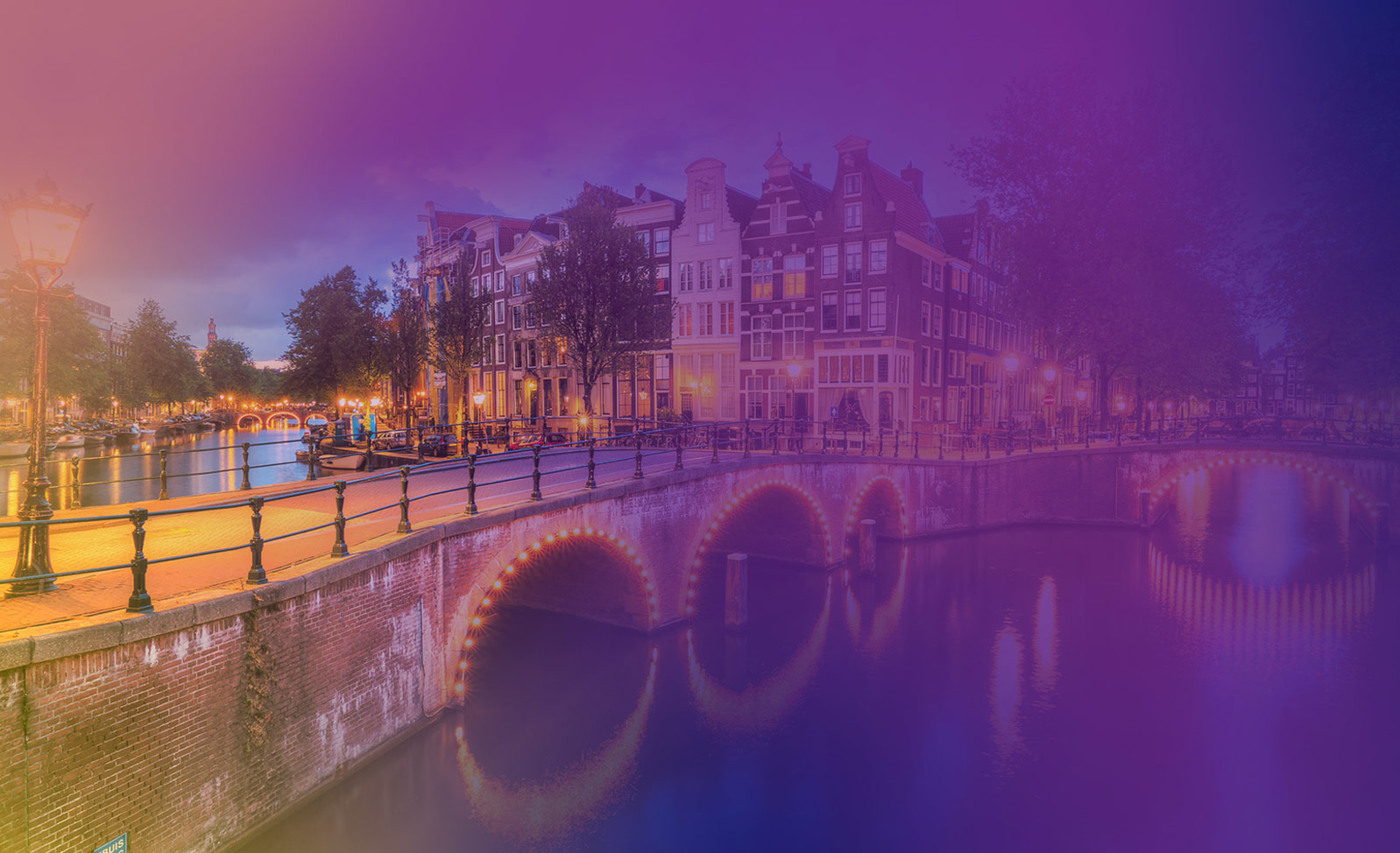 Bruggetje over een gracht in Amsterdam met weerspiegeling van het bruggetje in het water.